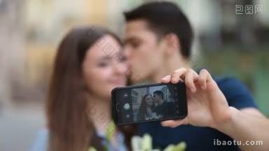 快乐的年轻情侣在度假旅行中用手机自拍，他们的注意力集中在智能手机上，模糊